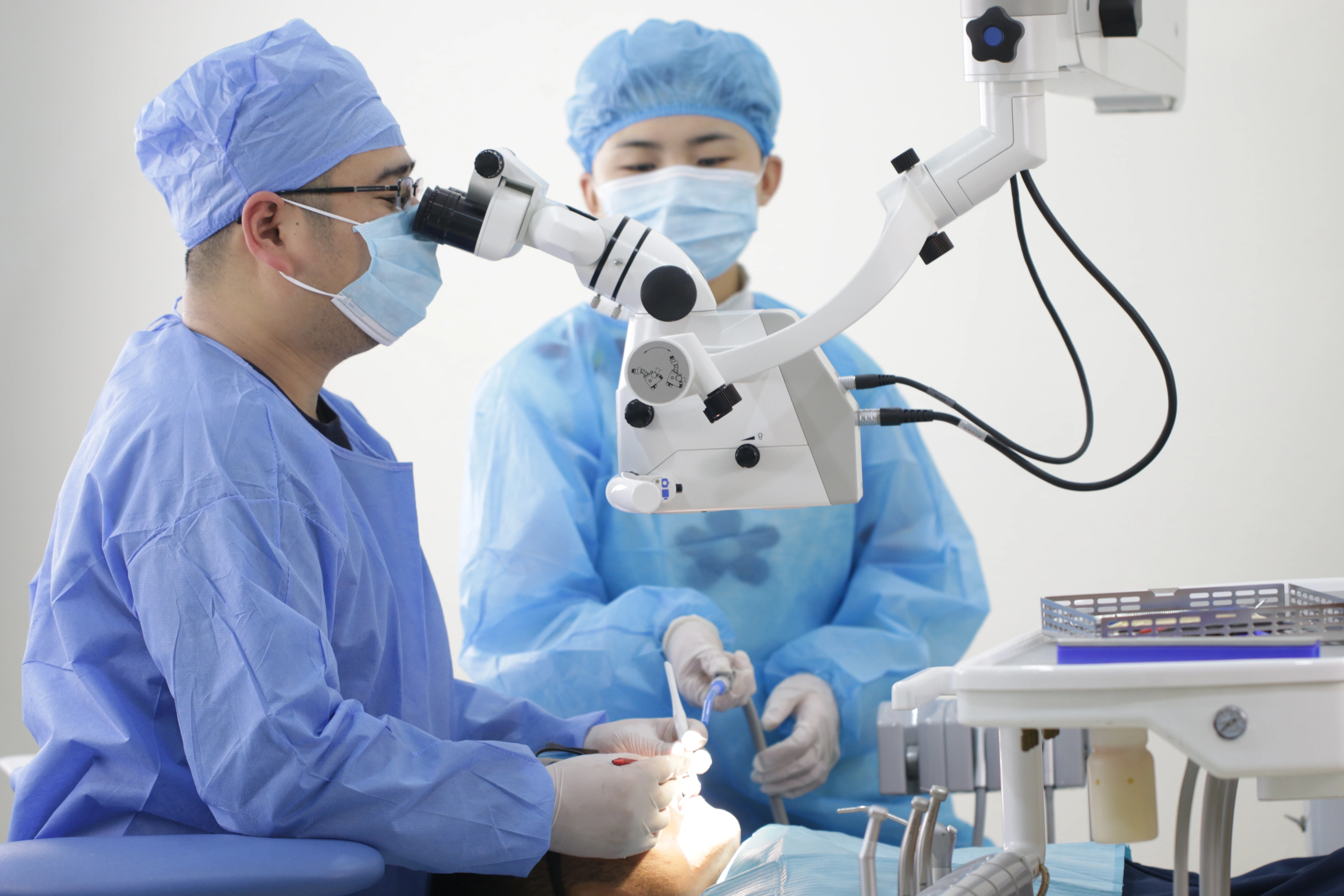 Chirurgien-dentiste travaillant au microscope dentaire Zumax